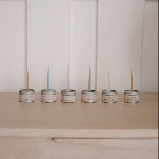 6 different colour candles inside 6 metal salt tins